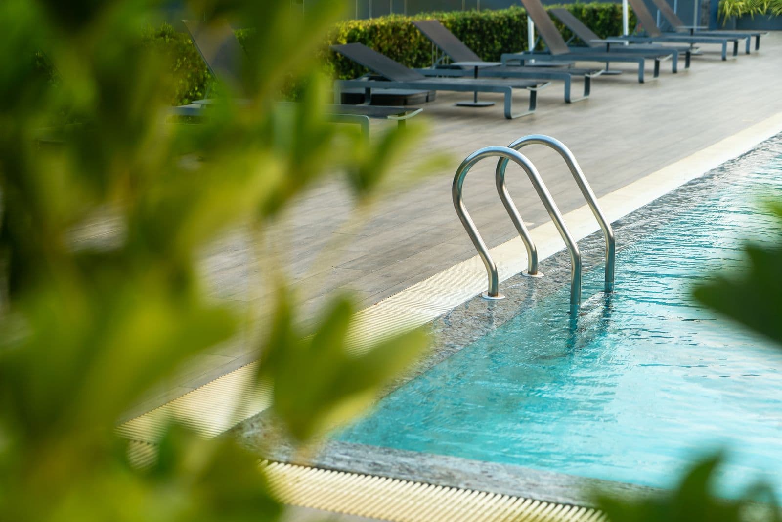 A sleek modern swimming pool with clear blue water and a clean lounge deck
